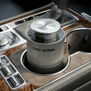Care Aroma DriveMist car diffuser placed in luxury car cup holder creating a calm and fresh driving experience